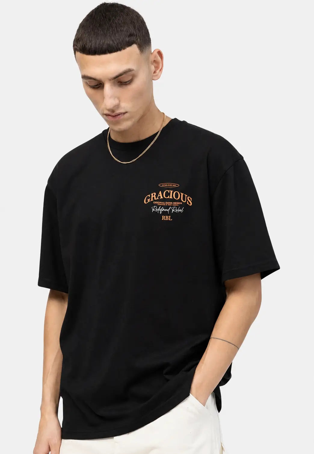 Front view of a black oversized T-shirt featuring a small chest graphic print with a relaxed streetwear fit